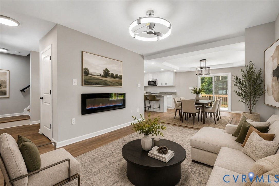 425 BYRNE Street, Petersburg, VA 23803 Open-concept living space anchored by a linear gas fireplace with a black surround, hardwood flooring throughout, and abundant natural light from multiple windows