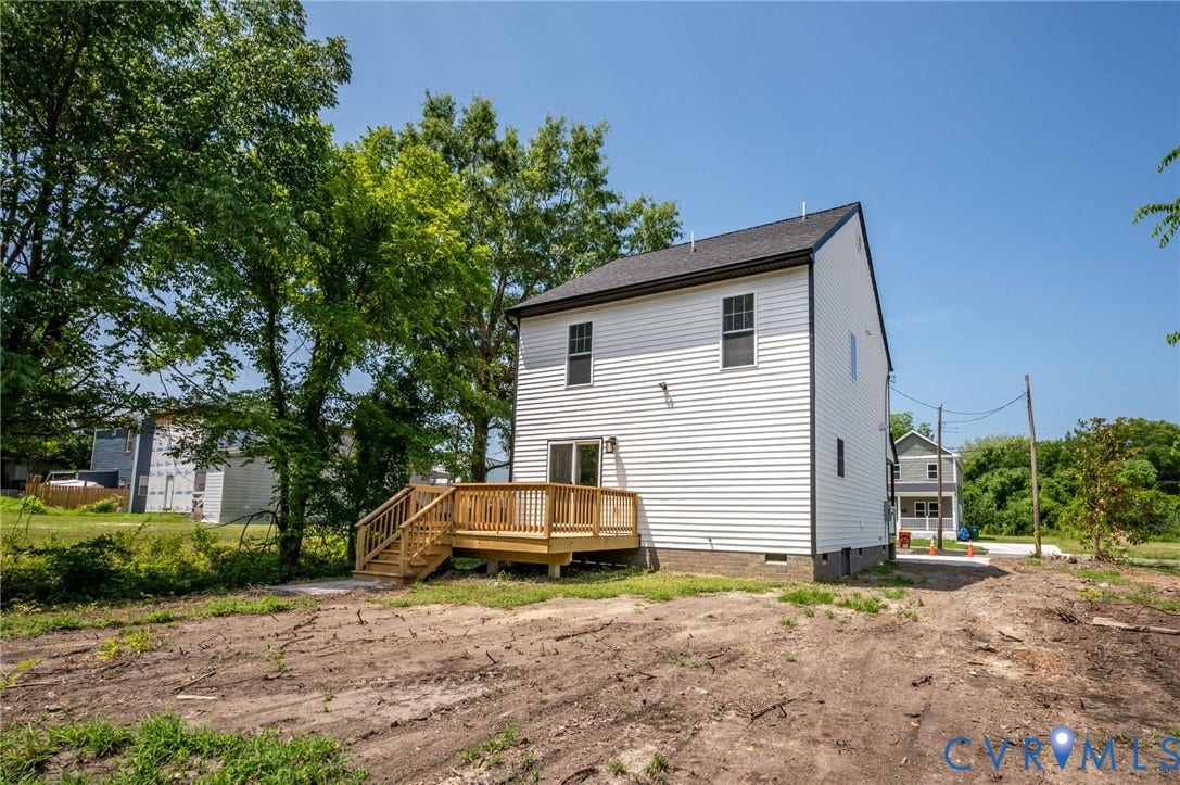425 BYRNE Street, Petersburg, VA 23803 Rear exterior featuring white horizontal siding, a black shingle roof, and a wooden deck with railing
