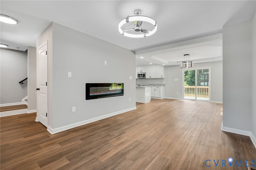 425 BYRNE Street, Petersburg, VA 23803 Open-concept living area with wood-finish flooring, a wall-mounted electric fireplace, and a contemporary ceiling fan