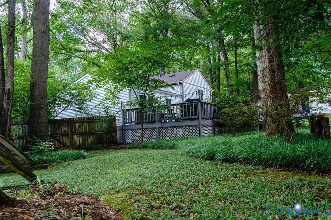 4900 Cord Court, Bridgewood, Glen Allen, VA 23060 Wooded residential setting featuring a charming cottage-style home with a wraparound deck, positioned on an expansive lawn surrounded by mature trees