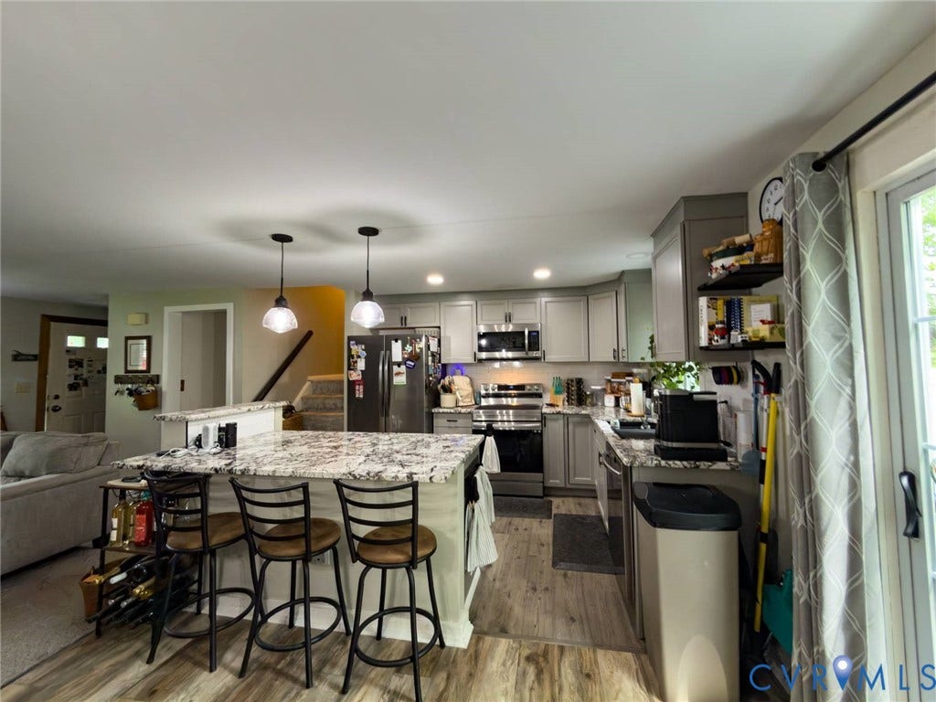4900 Cord Court, Bridgewood, Glen Allen, VA 23060 Kitchen with gray cabinetry, stainless steel appliances, a center island with seating, and wood-finish flooring
