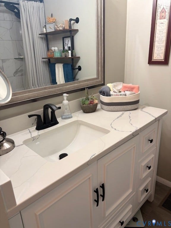 4900 Cord Court, Bridgewood, Glen Allen, VA 23060 White vanity with an integrated sink, black faucet, and white countertop featuring veining