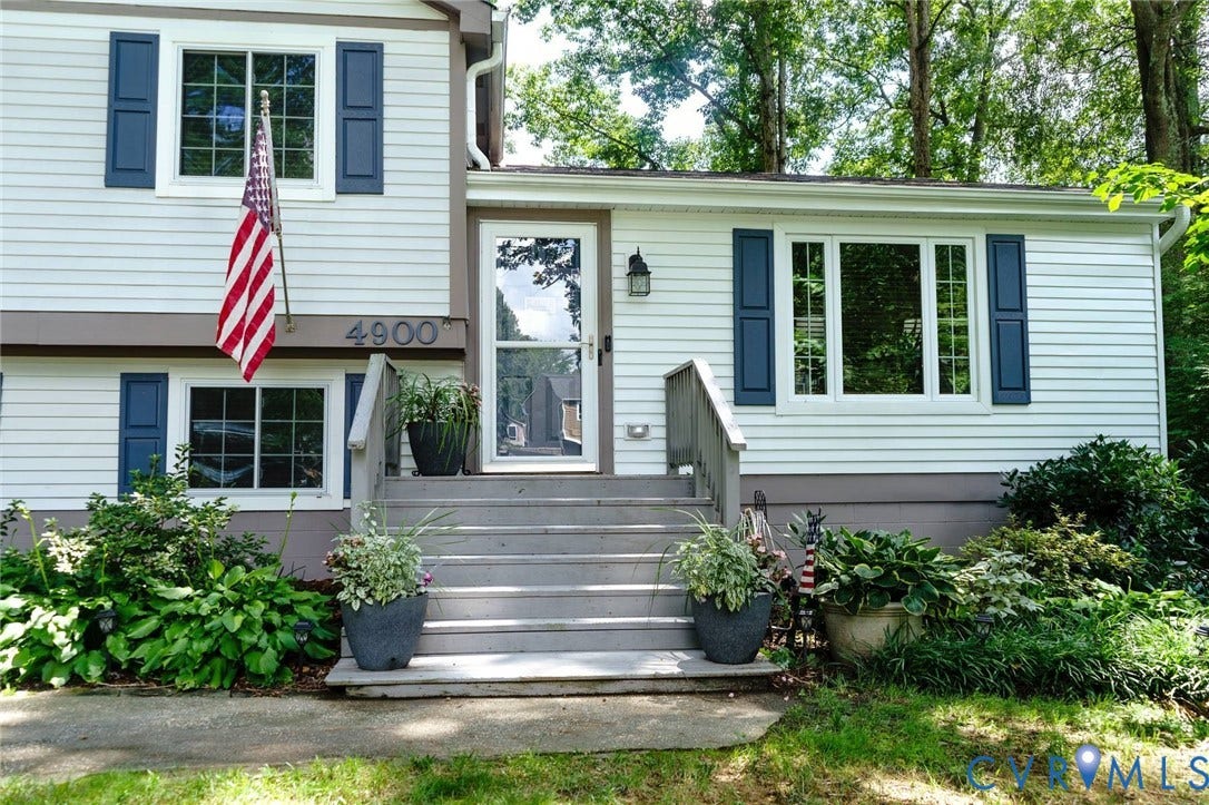 4900 Cord Court, Bridgewood, Glen Allen, VA 23060 White siding exterior with dark blue decorative shutters, a glass storm door, and an exterior wall lantern