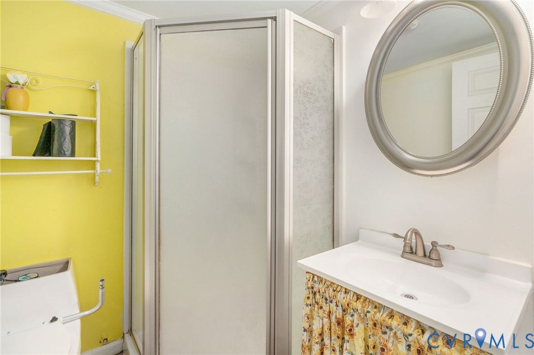 5927 Swanson Road, Richmond, VA 23225 Bright and functional bathroom featuring a crisp white vanity with an undermount sink and brushed nickel faucet, paired with a decorative fabric skirt