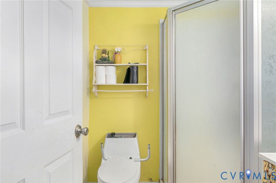 5927 Swanson Road, Richmond, VA 23225 Bathroom featuring a shower enclosure with frosted glass, a toilet, and a wall-mounted shelving unit