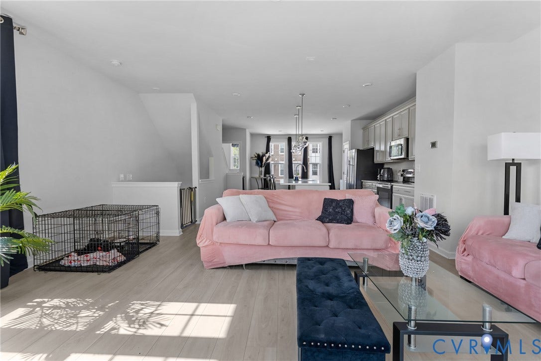Bright, open-concept living area showcasing light wood-finish flooring, expansive windows with natural illumination, and modern architectural details