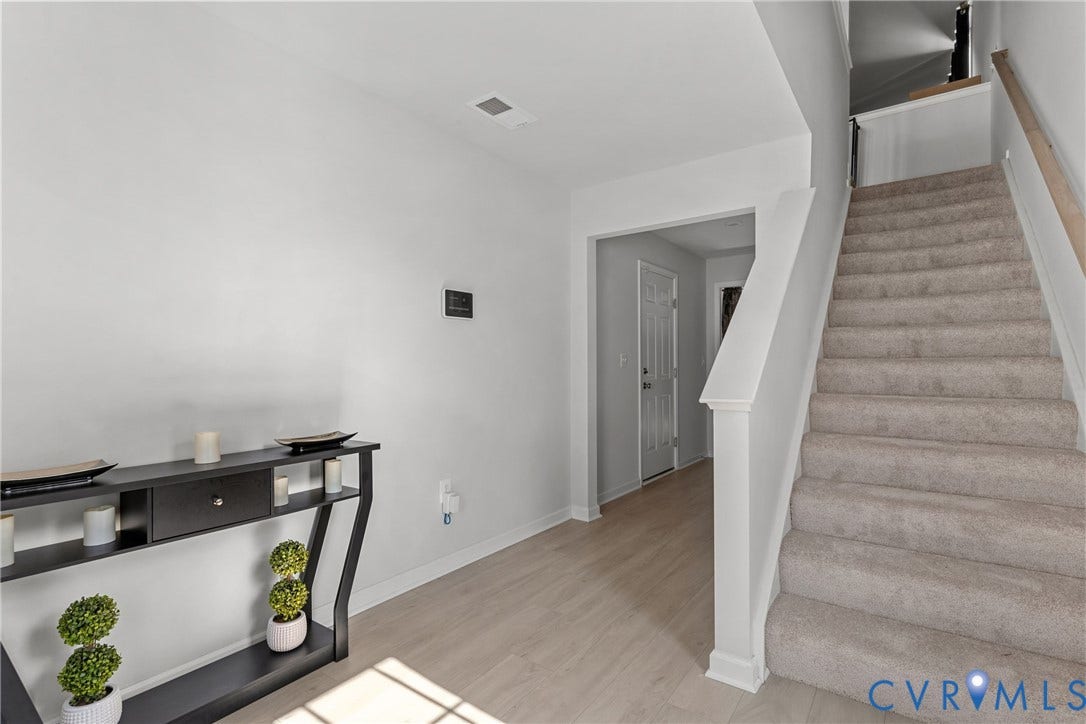 Carpeted staircase with light wood-finish flooring