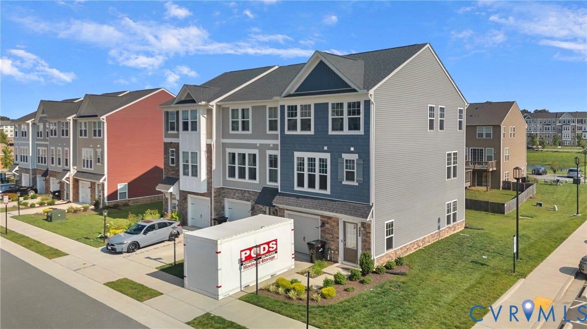 Contemporary townhome with a multi-textured facade featuring siding and stone accents