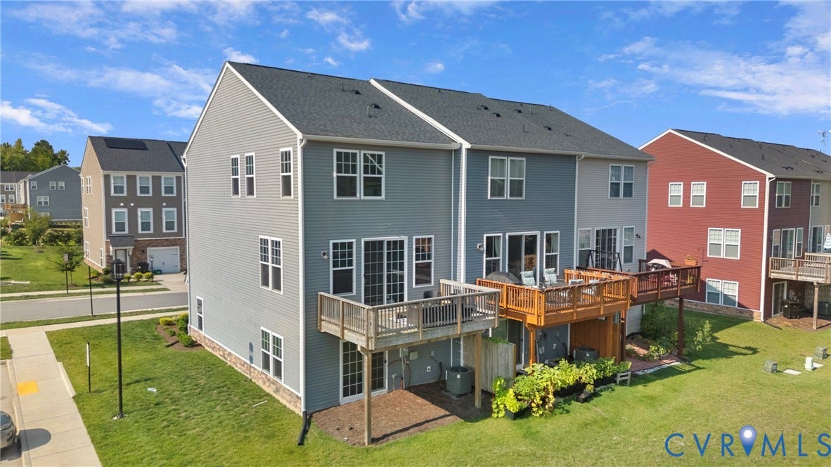 Modern three-story residence featuring a light blue exterior with gabled rooflines and multiple windows providing abundant natural light