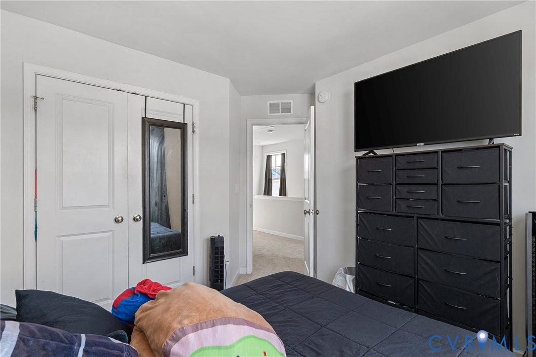 White interior walls with a double-door closet featuring panel detailing and round door knobs