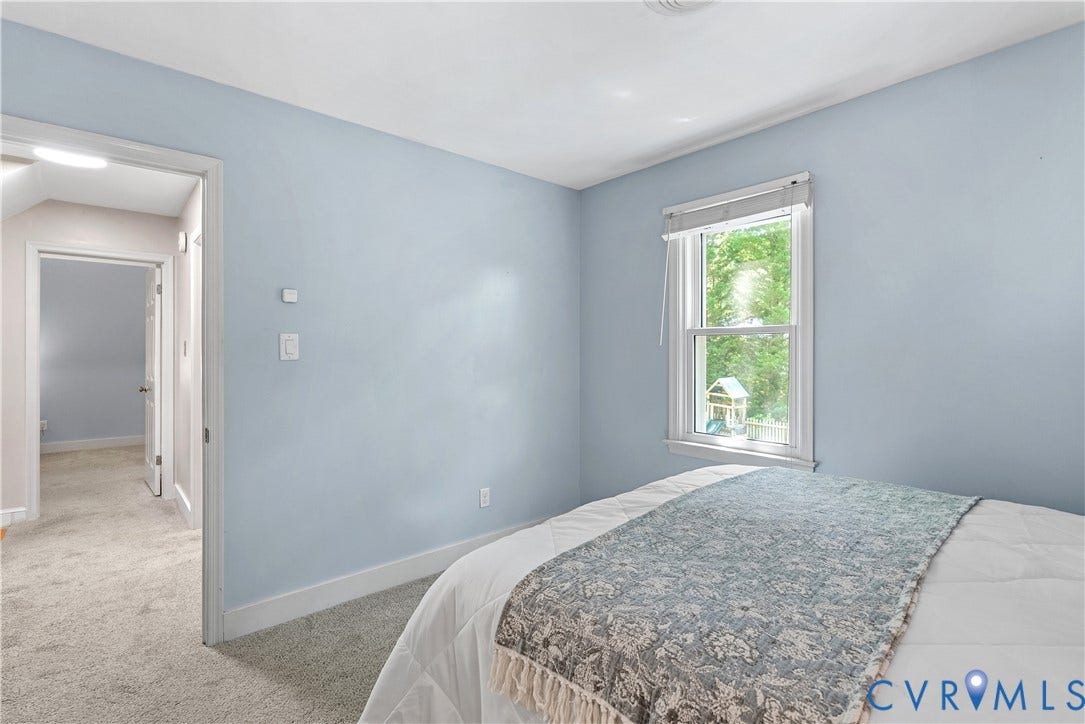 Carpeted flooring, single window, door frame, and light blue wall finish