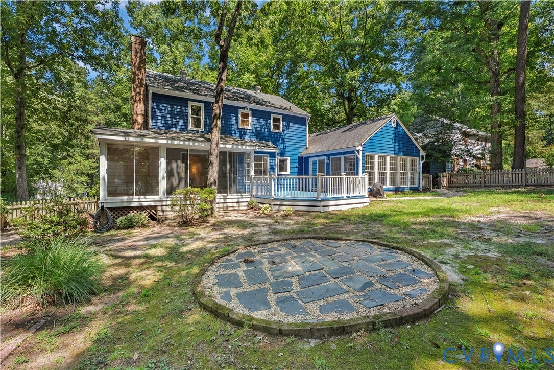 Blue exterior siding with white trim, screened porch, sunroom, outdoor deck, and a circular stone patio