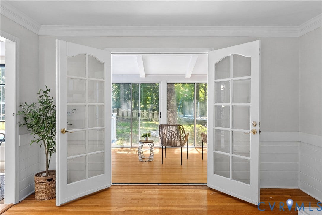 Hardwood flooring, French doors, crown molding, wainscoting, and a sunroom with exposed beams
