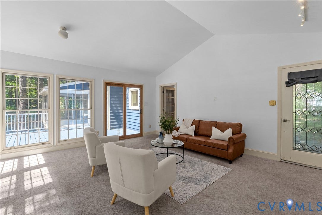 Bright, open living area flooded with natural light through multiple glass doors and windows