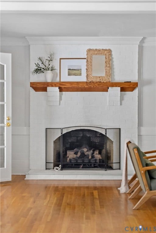 White brick fireplace with a wood mantle and hearth