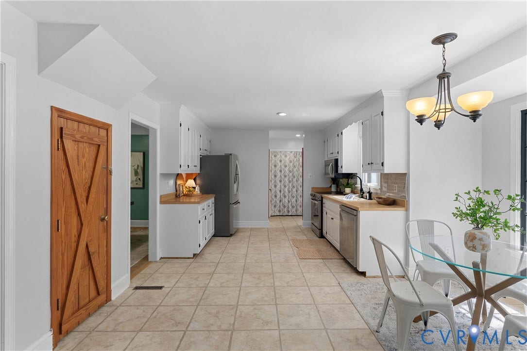 Kitchen featuring white cabinetry, light wood-finish countertops, stainless steel appliances, and tiled flooring