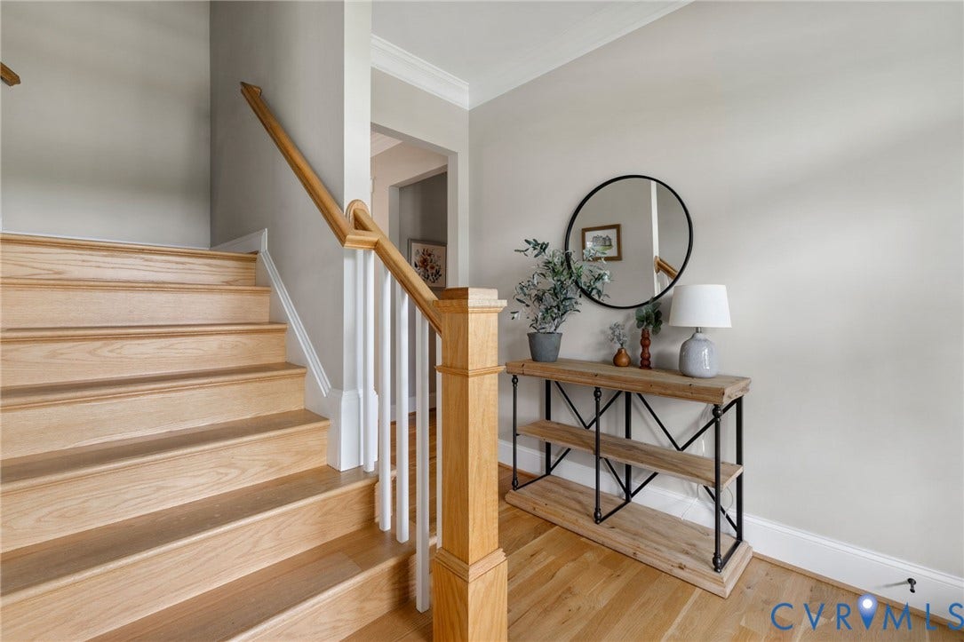 7237 Bonallack Bend, Carlton Ridge, Moseley, VA 23120 Elegant foyer showcasing a wood staircase with white railings and a matching wooden handrail, warm wood-finish flooring throughout