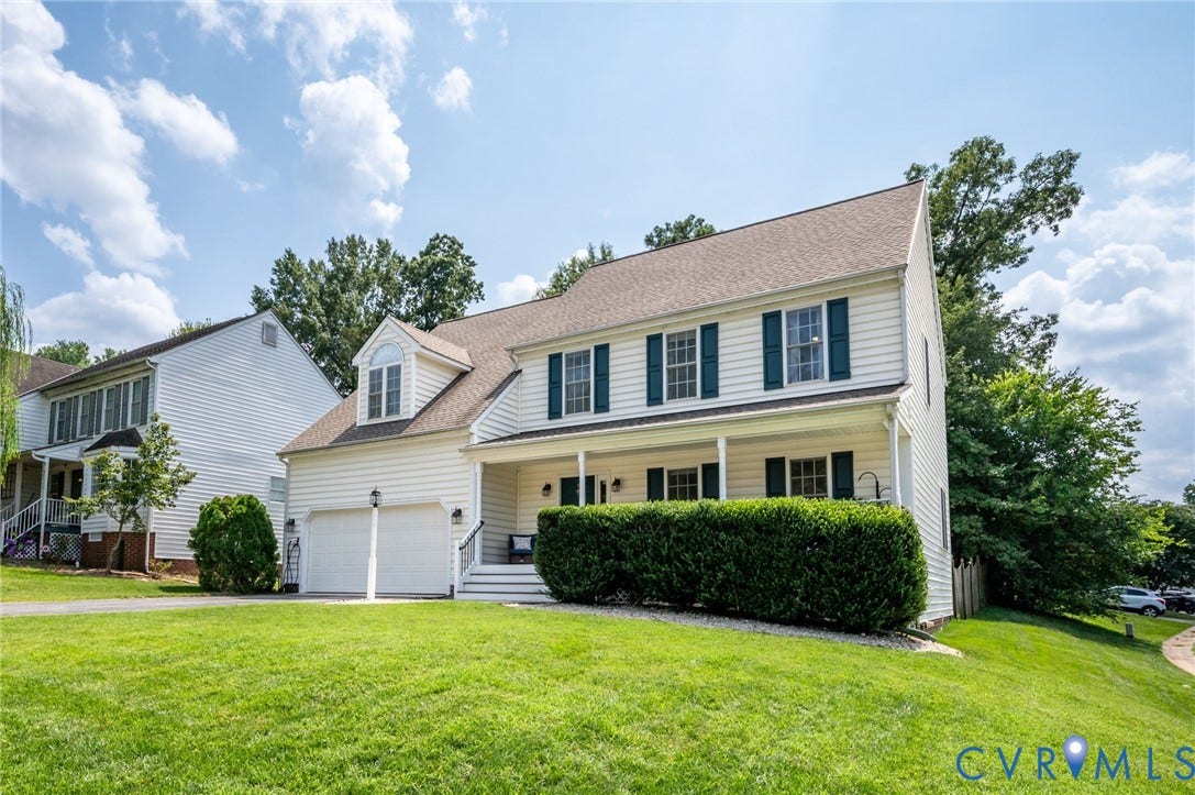 10620 Correnty Drive, Henrico, VA 23059 Traditional two-story residence with white siding, dark green shutters, an attached two-car garage, covered front porch, and dormer window