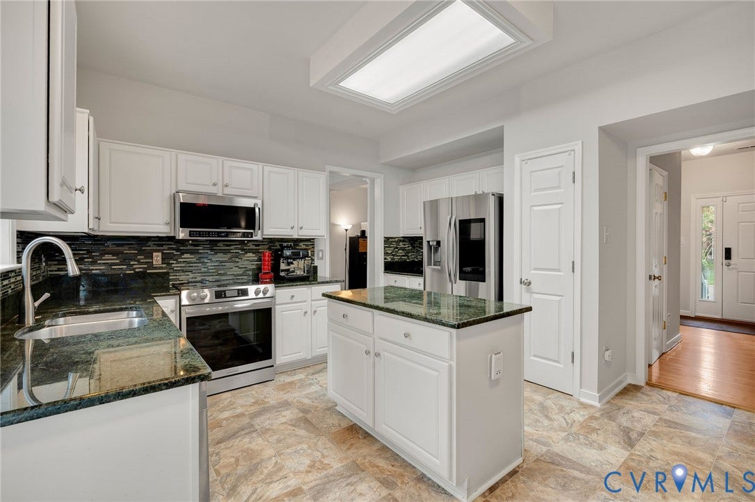 10620 Correnty Drive, Henrico, VA 23059 Kitchen featuring white cabinetry, stone countertops, stainless steel appliances, a tile backsplash, and an island with additional storage