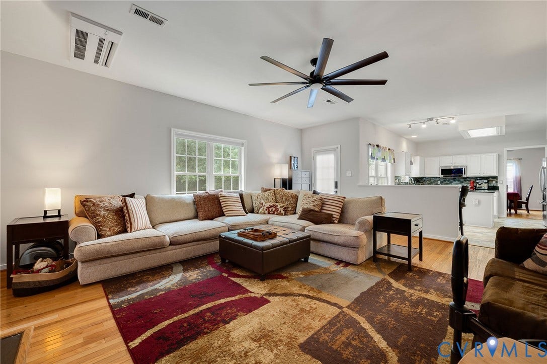 10620 Correnty Drive, Henrico, VA 23059 Open-concept living space featuring wood-finish flooring, a contemporary ceiling fan, and a large window