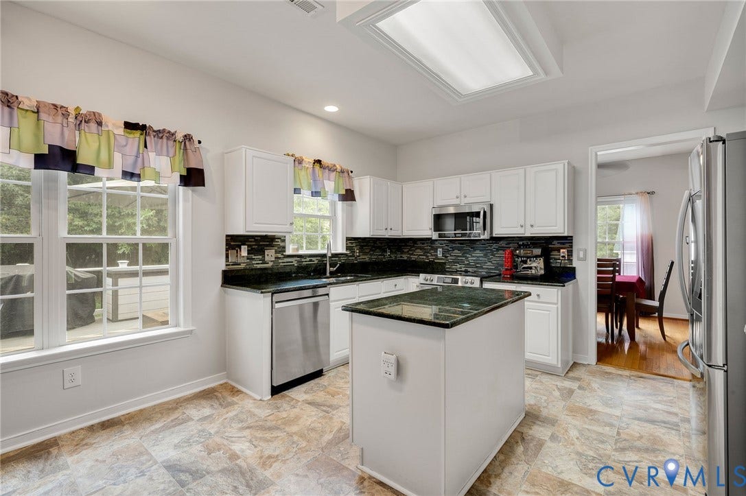 10620 Correnty Drive, Henrico, VA 23059 Kitchen featuring a central island with stone countertop, white cabinetry, dark stone backsplash, stainless steel appliances, and tile flooring