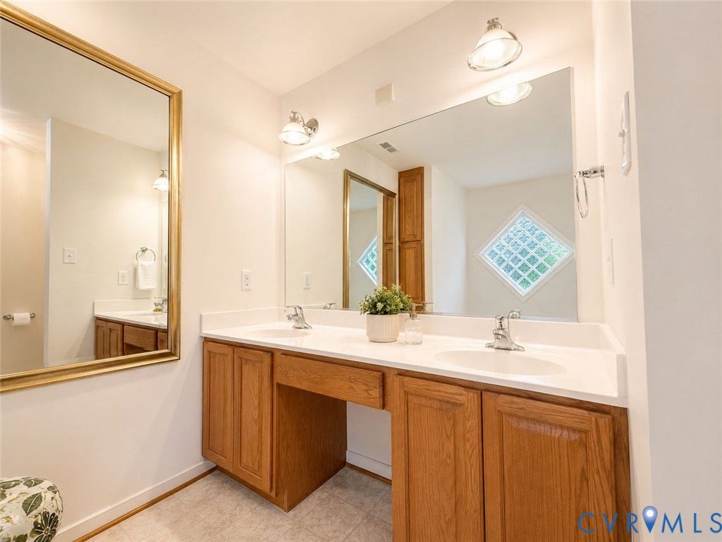 Amelia, VA 23966 Double vanity featuring wood-finish cabinetry, white countertops, and dual integrated sinks