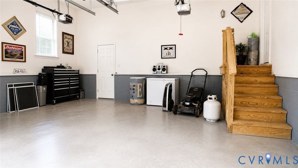 Amelia, VA 23966 Spacious garage featuring an overhead door, smooth concrete flooring, and a dedicated utility door