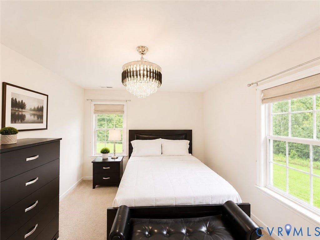 Amelia, VA 23966 White walls and light neutral carpet flooring create a bright atmosphere, enhanced by a crystal chandelier