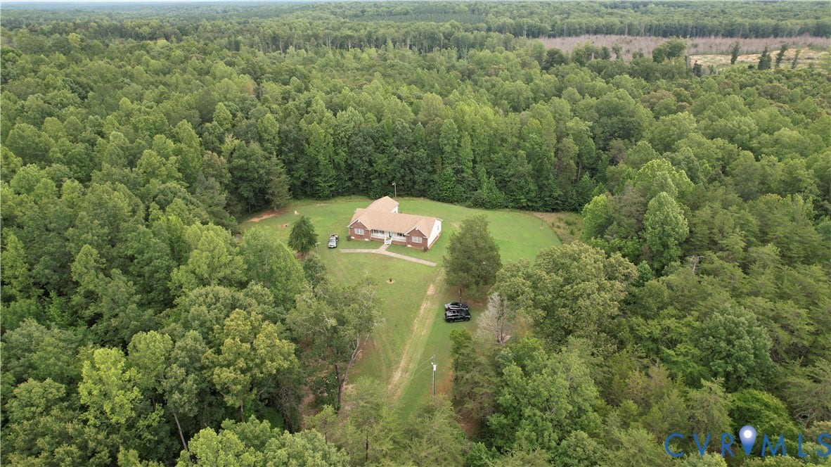 Amelia, VA 23966 Expansive property featuring a single-story residence with a brick exterior and a brown shingle roof, surrounded by mature trees