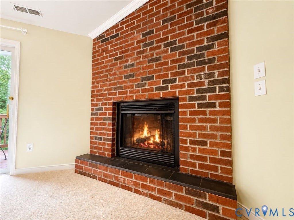 Amelia, VA 23966 Brick fireplace with a black firebox and a dark tile hearth