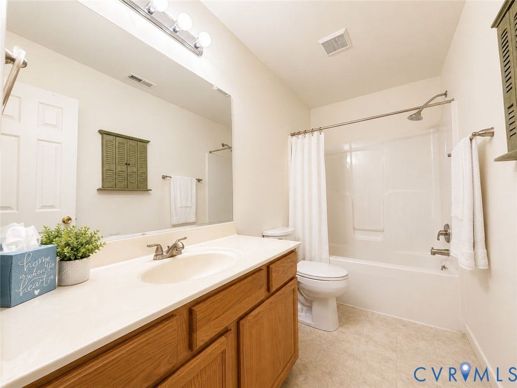 Amelia, VA 23966 Full bathroom with a tub/shower combination, a vanity featuring wood-finish cabinetry, and a light-toned countertop with an integrated sink