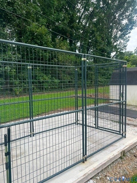 11925 Wedge Drive, Chester, VA 23831 Outdoor enclosure with dark gray metal fencing, concrete flooring, and a gravel perimeter