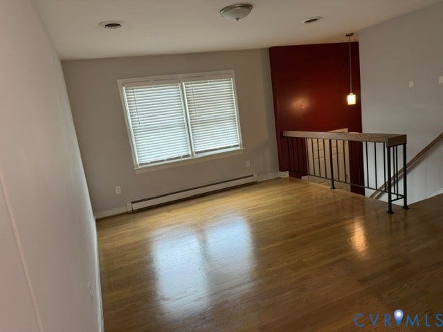 11925 Wedge Drive, Chester, VA 23831 Spacious open area featuring wood-finish flooring, a contemporary railing with black balusters and a wood-finish top, and a window with blinds