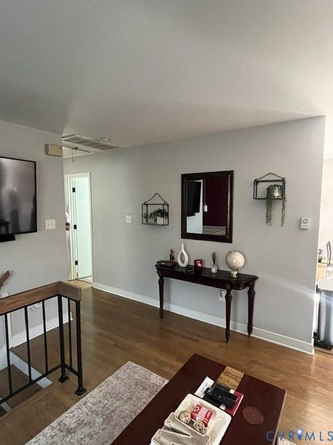 11925 Wedge Drive, Chester, VA 23831 Hardwood flooring featuring a light wood finish and a black metal railing with a wood-finish top cap