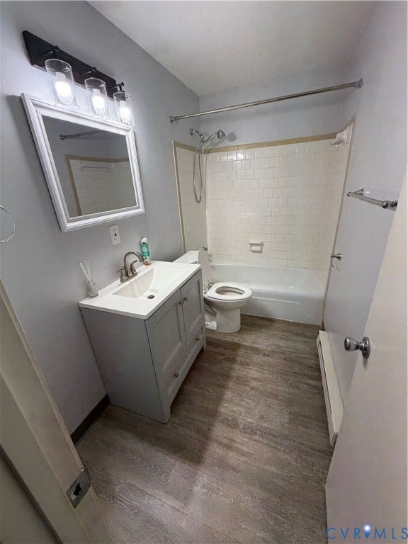 11925 Wedge Drive, Chester, VA 23831 Bathroom with a light gray vanity and white countertop, wood-finish flooring, and a white subway tile tub surround
