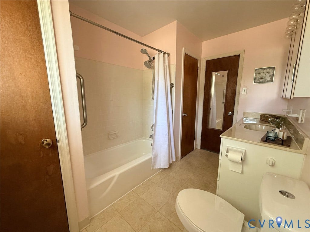 6401 Lythgoe Avenue, North Chesterfield, VA 23234 Built-in vanity with integrated sink, white tile flooring, and white bathtub with grab bar
