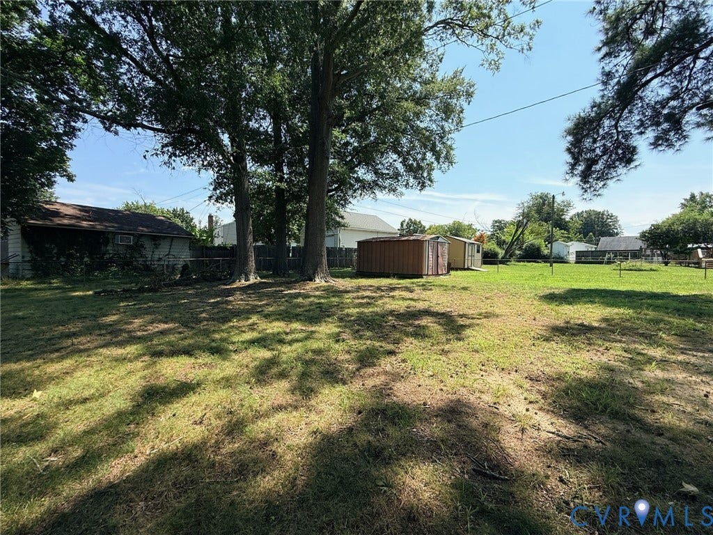 6401 Lythgoe Avenue, North Chesterfield, VA 23234 Expansive grassy yard with mature trees and a chain link fence