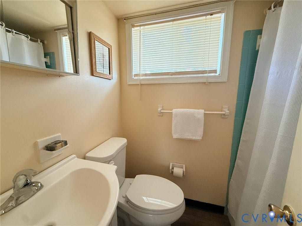 6401 Lythgoe Avenue, North Chesterfield, VA 23234 Bathroom featuring a white toilet, wall-mounted sink, and a medicine cabinet with mirror
