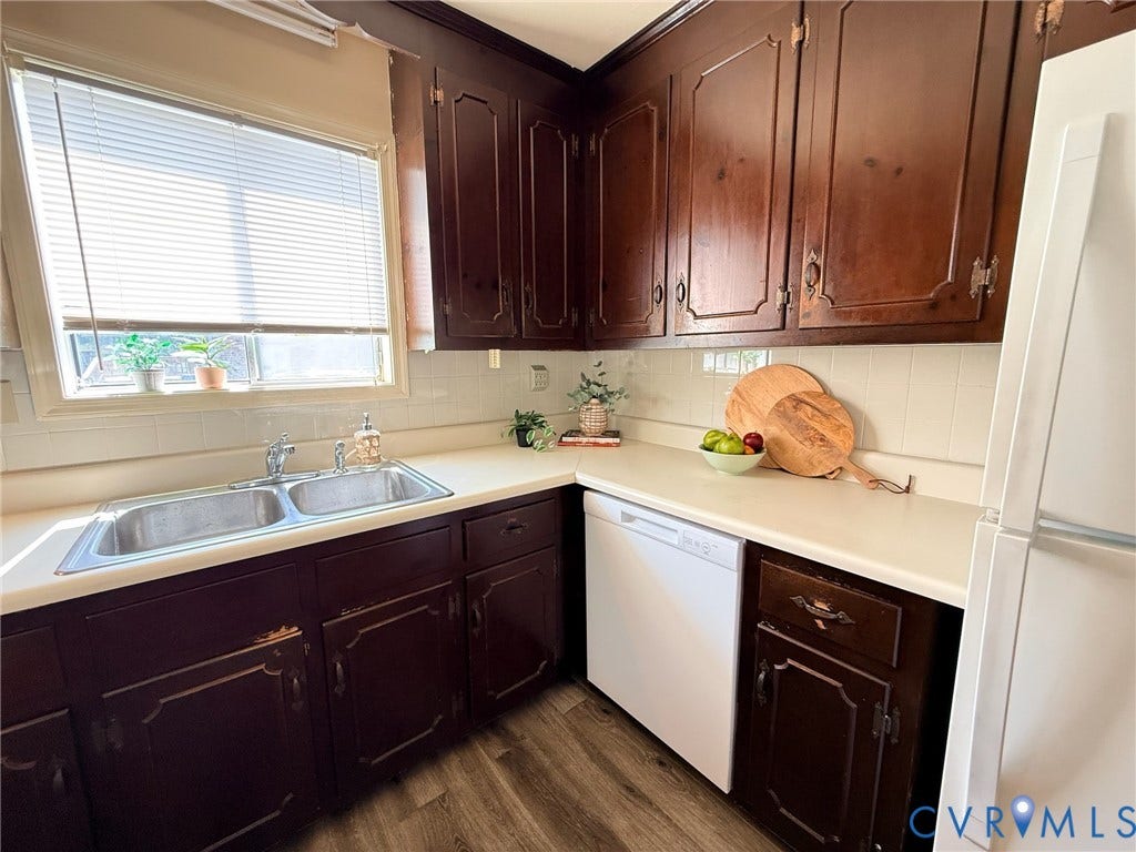 6401 Lythgoe Avenue, North Chesterfield, VA 23234 Wood-finish flooring, dark wood cabinetry, light countertops, white tile backsplash, and a double basin sink
