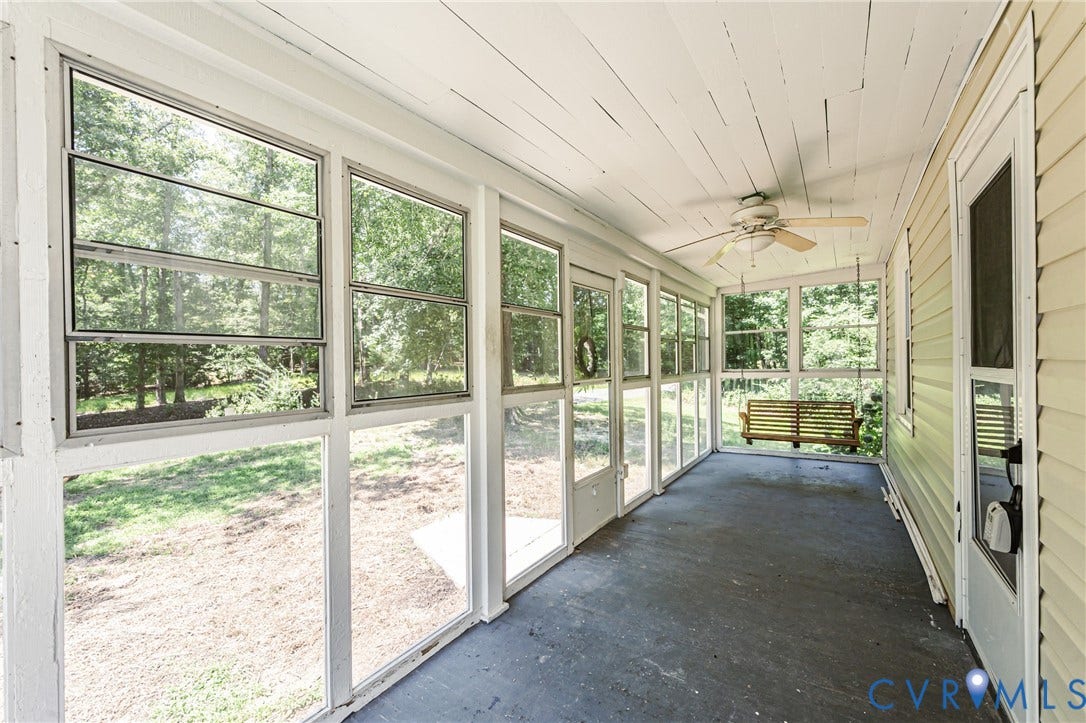 Enclosed porch with a slatted wood ceiling, ceiling fan, and multiple windows