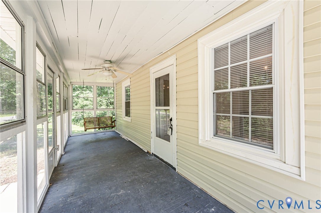Screened-in porch featuring a plank ceiling, a ceiling fan, light-colored siding, and multiple windows