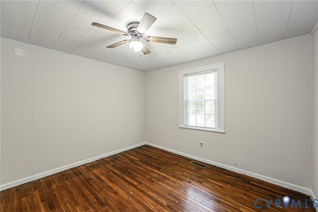 Hardwood flooring complements the neutral wall paneling