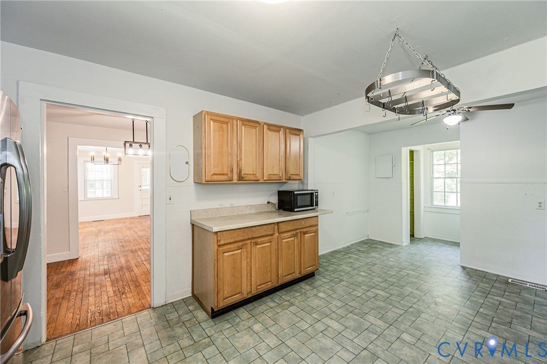 Kitchen featuring light wood-finish cabinetry, a light-toned countertop, and patterned floor tiling