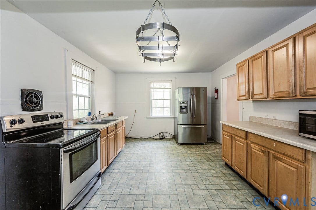 Spacious kitchen featuring light wood cabinetry, light countertops, and a stainless steel refrigerator
