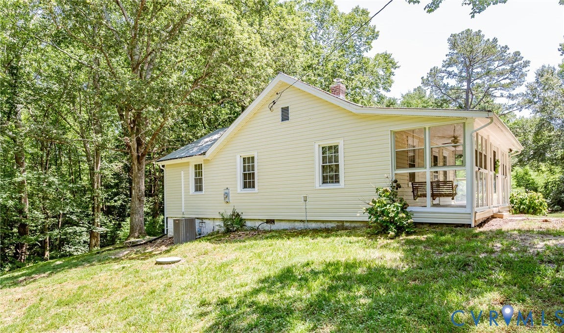Light yellow siding exterior with white trim windows and a screened-in porch