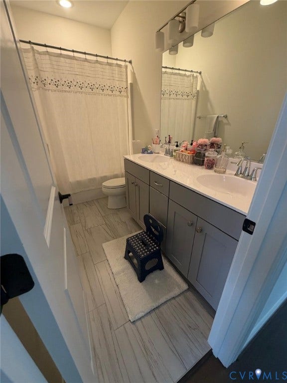 4516 Bacova Club Court, Glen Allen, VA 23059 Bathroom featuring a dual vanity with undermount sinks, gray cabinetry, a full-width mirror, and a shower-tub combination