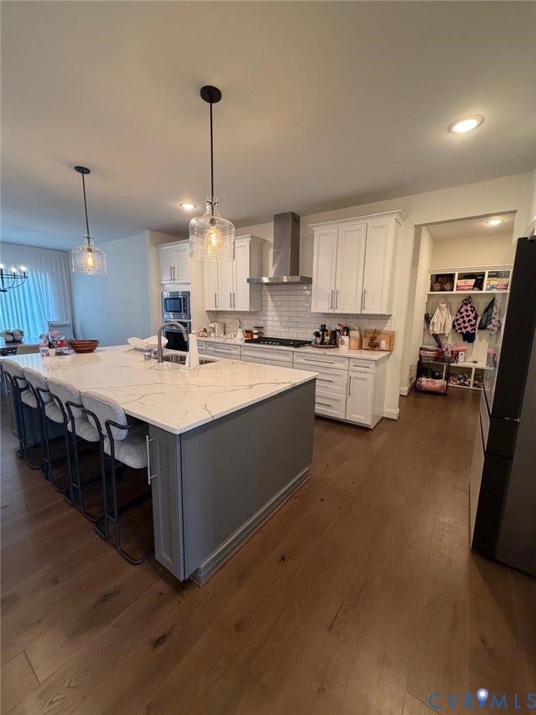 4516 Bacova Club Court, Glen Allen, VA 23059 Gourmet kitchen featuring a large island with seating, stone countertops, white cabinetry, stainless steel appliances, and wood-finish flooring