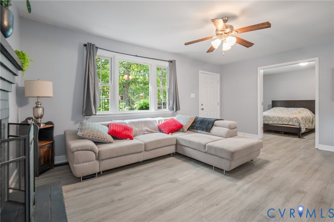 3940 Three Bridge Road, Powhatan, VA 23139 Light gray walls, wood-finish flooring, ceiling fan, and a wide window with exterior greenery