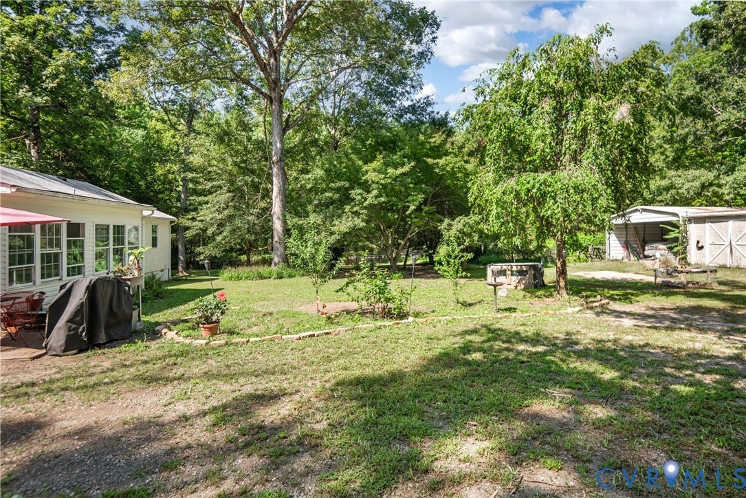 3940 Three Bridge Road, Powhatan, VA 23139 Expansive green lawn with mature trees and a detached outbuilding