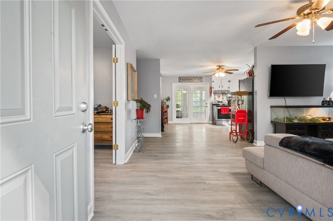 3940 Three Bridge Road, Powhatan, VA 23139 Light grey plank flooring extending throughout, ceiling fans with integrated lighting, and white French doors